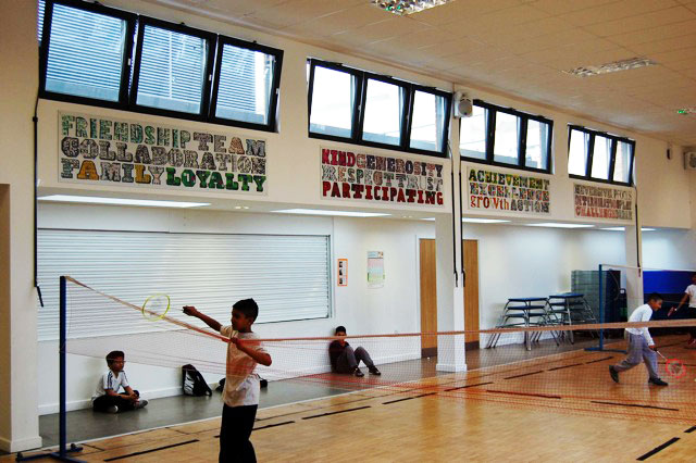 Lettering on the walls in the school hall with the children playing sport